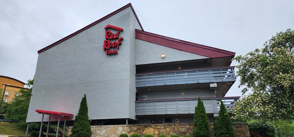 Un Red Roof Inn dall'architettura moderna, caratterizzato da un tetto rosso ben visibile e una insegna con il nome dell'albergo.