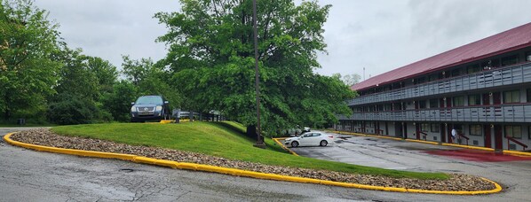 A parking lot with a building featuring a red roof and multiple windows. - Red Roof Inn PLUS+ Pittsburgh East - Monroeville (Monroeville)