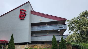 A Red Roof Inn with a modern architectural design, featuring a prominent red roof and a sign with the inn's name.
