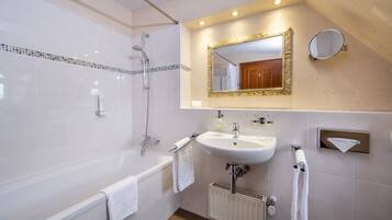 Ein modernes Badezimmer mit Badewanne, Waschbecken und Dusche.