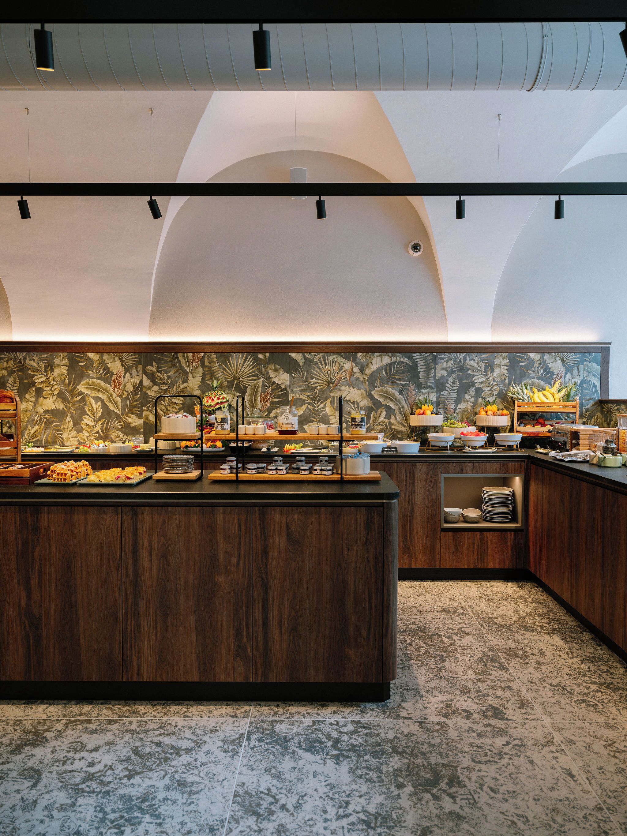 A modern kitchen with a central island, equipped with various food items and utensils.