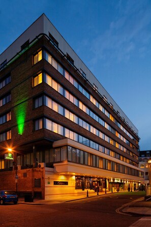 Un hotel a più piani dal design architettonico moderno, con tetto piatto, ampie finestre e un ingresso ben illuminato.