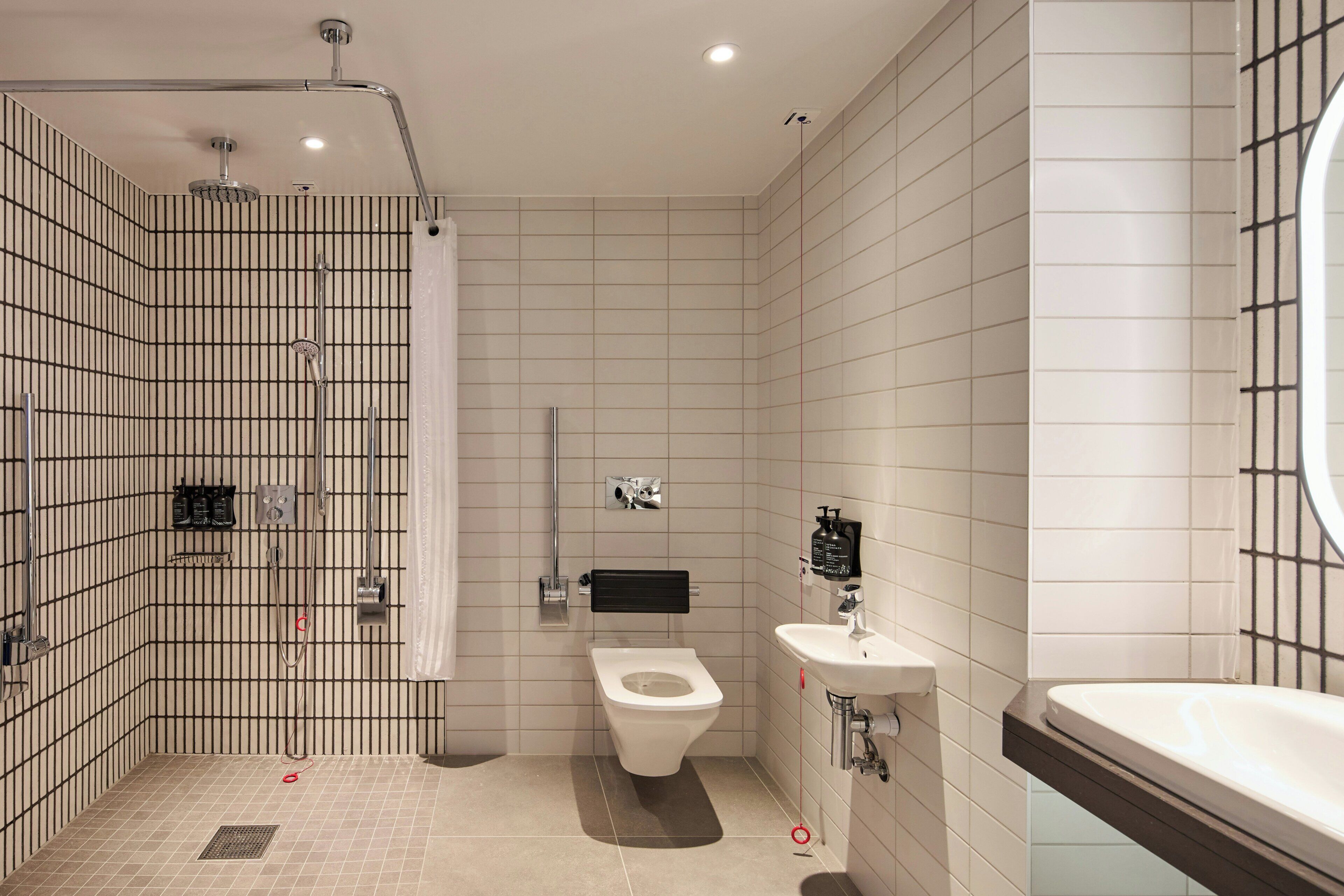 A modern bathroom with a shower, toilet, and sink.