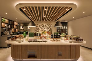 A modern kitchen with a central island, wooden paneling, and pendant lighting. - Holiday Inn London-Bloomsbury Hotel by IHG (London)