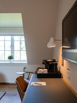 Una cocina moderna con una cafetera, una mesa pequeña y una silla.