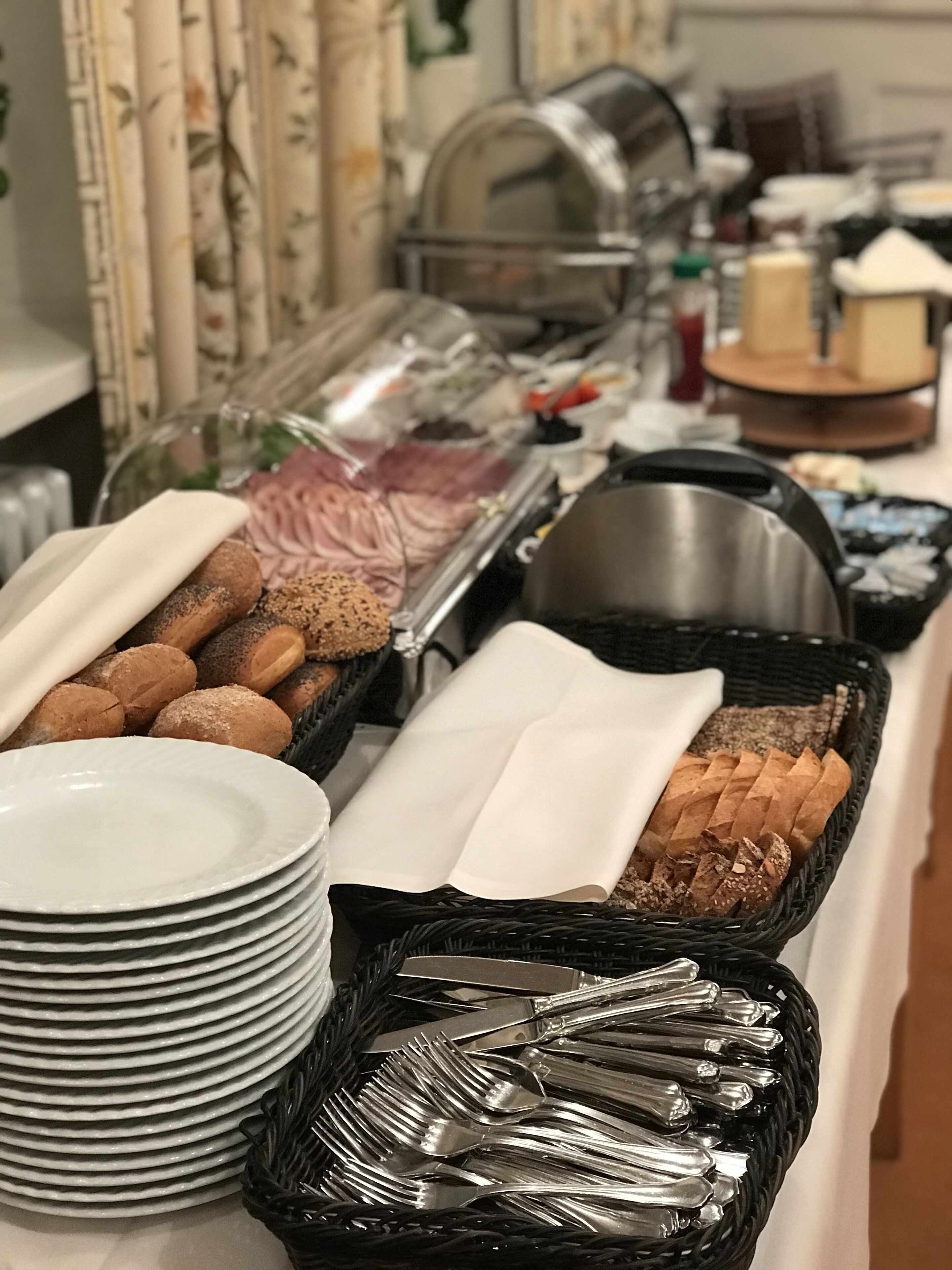 Una mesa de buffet con diversos alimentos y utensilios.