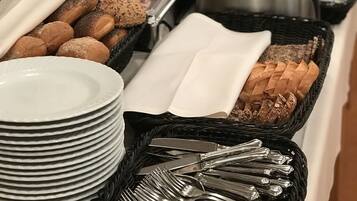 Una mesa de buffet con diversos alimentos y utensilios.