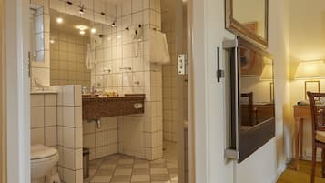 A bathroom with a toilet, sink, and mirror.