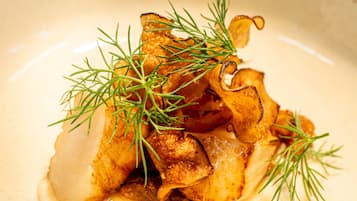 A plate of food with a creamy sauce and garnished with green herbs.