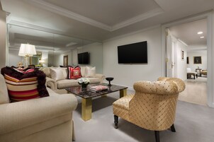 A modern living room with a sofa, armchair, coffee table, and a large mirror.