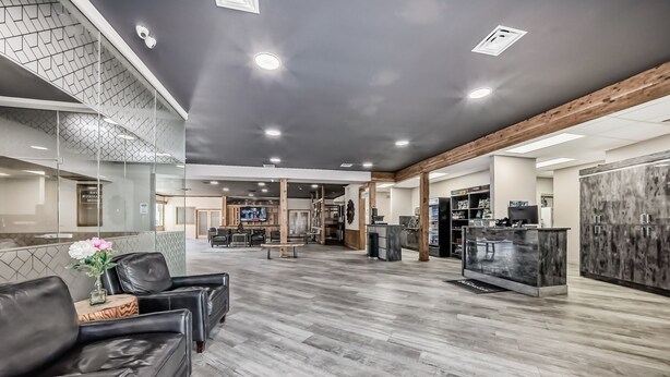 A spacious lobby with leather seating, a reception desk, and a modern interior design.