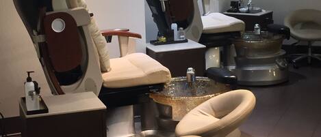 A salon with multiple treatment chairs, a central sink, and a mirror.