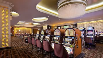 Un casino doté de nombreux distributeurs automatiques de jeux, de plusieurs bars et d’un lustre.