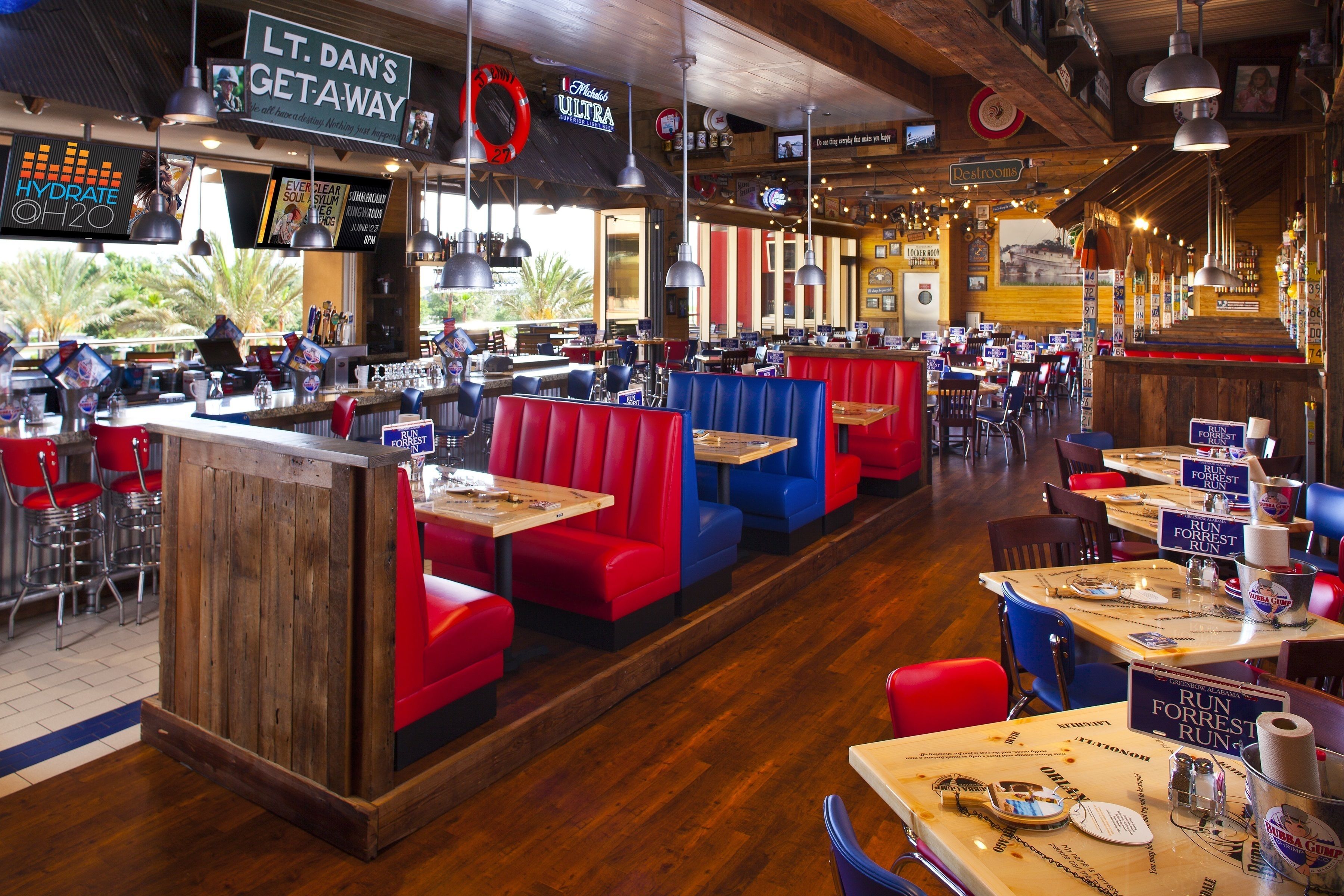 A restaurant with booths and tables, a bar area, and a restroom sign.