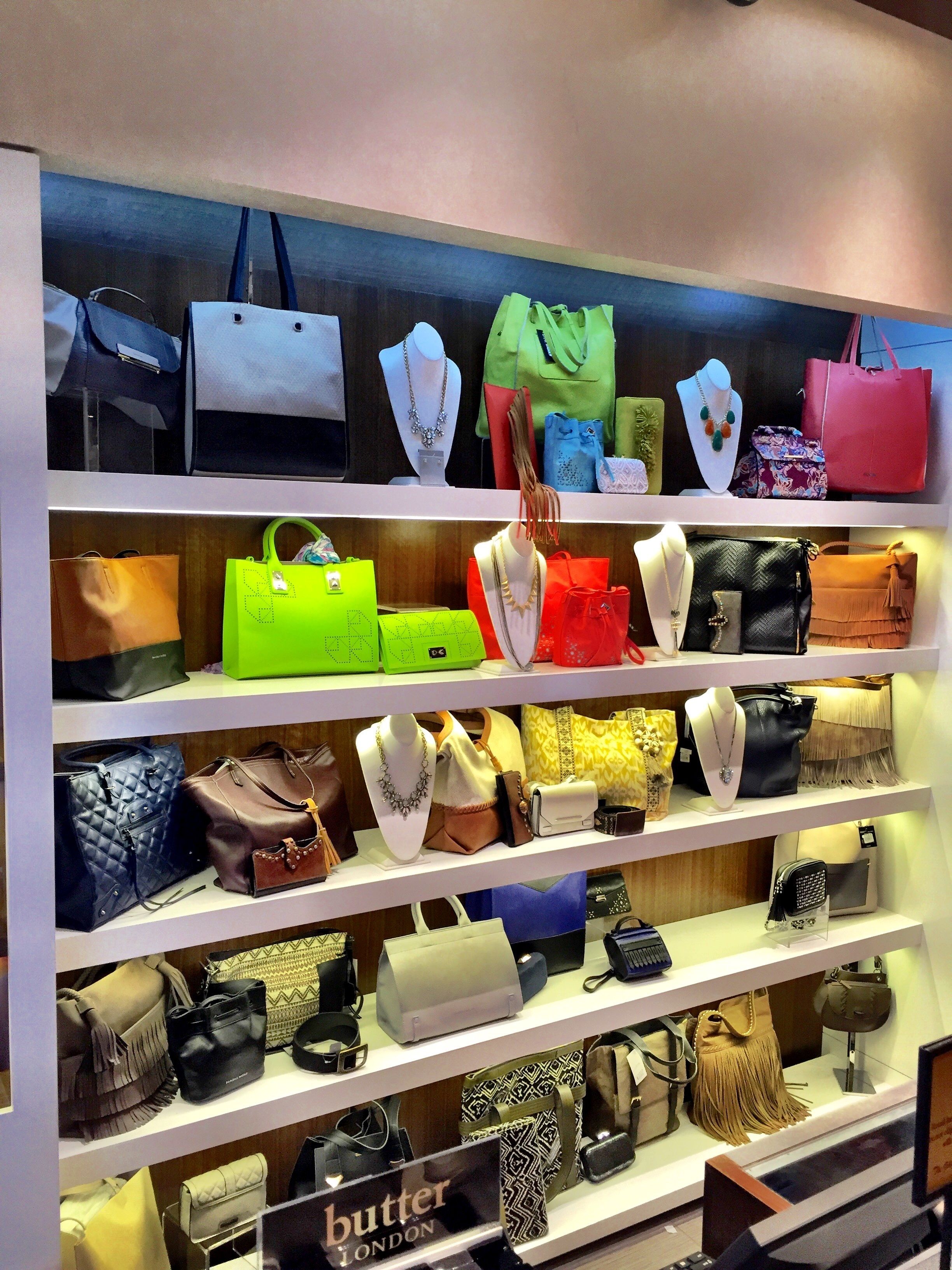 Una exposición de bolsos en estanterías en una tienda.