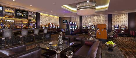 A modern bar area with leather seating, a bar counter, and a variety of liquor bottles.