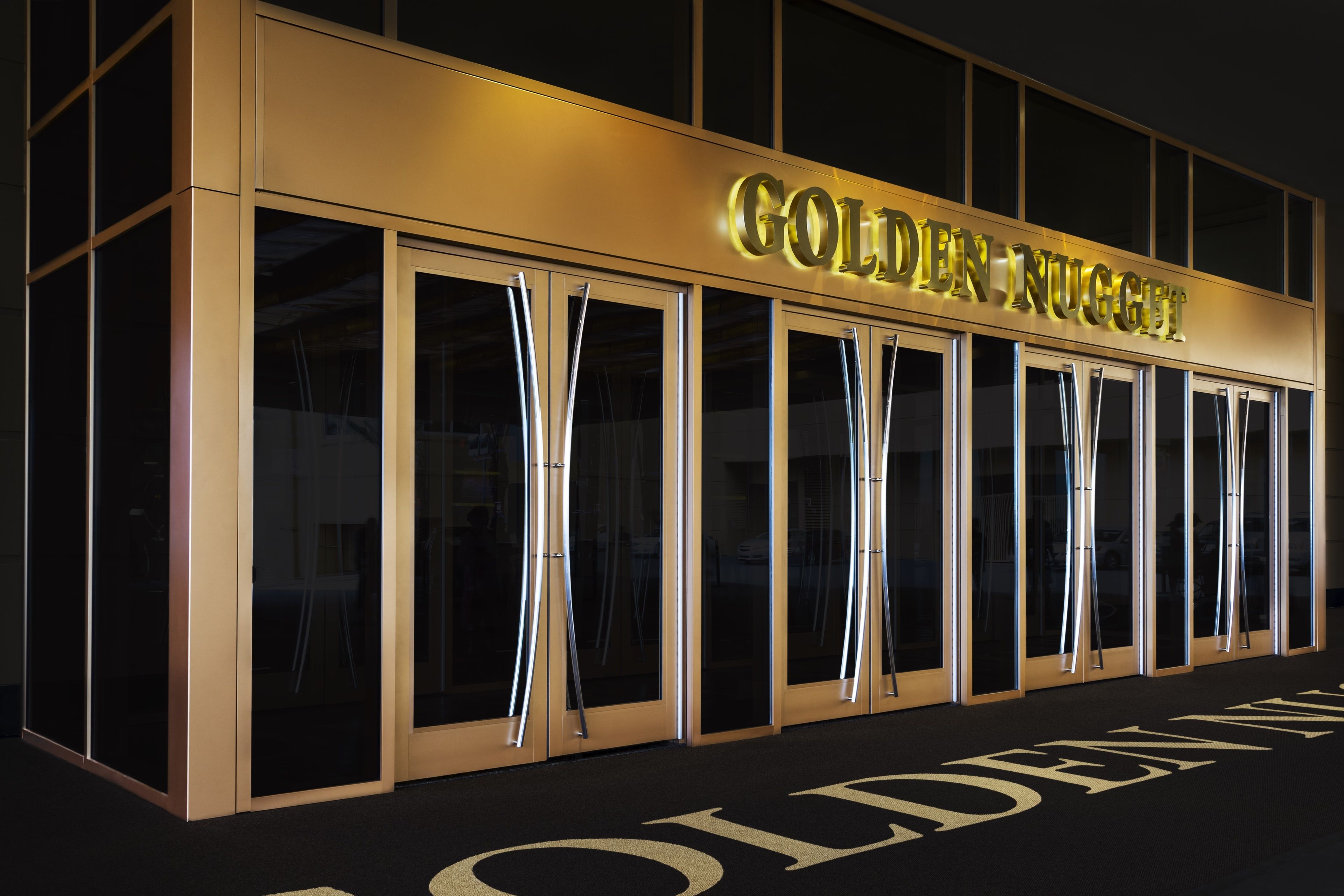 The exterior of the Golden Nugget hotel with its name illuminated in gold letters.