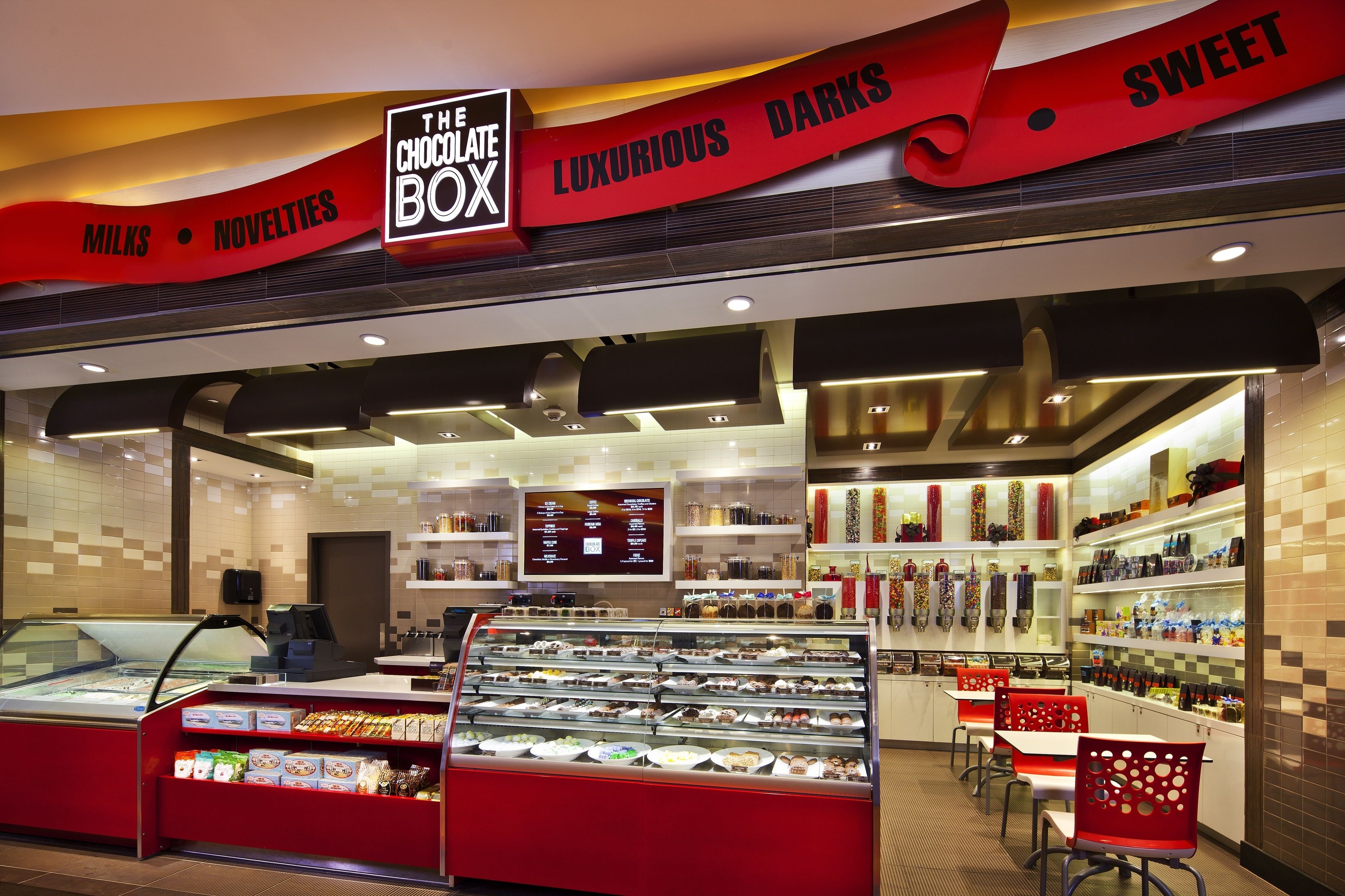 Una chocolatería con una vitrina de bombones y un letrero que dice "The Chocolate Box".