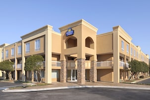 Edificio de Days Inn & Suites con fachada color beige, varios balcones y cielo despejado.