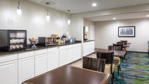 A hotel dining area with a buffet, seating, and a framed picture on the wall. - Days Inn by Wyndham Greenville (Greenville)