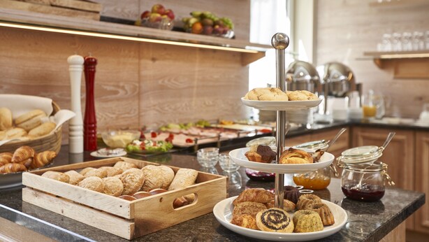 Un bufé de desayuno con pasteles, muffins y mermeladas.