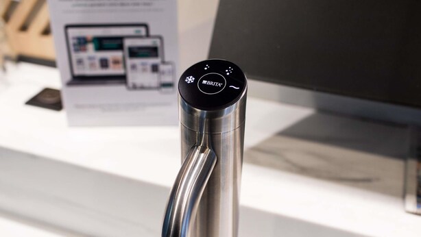 A modern, stainless steel faucet with a digital interface, likely part of a high-end bathroom setup.