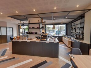 Una cocina moderna con una isla central, estanterías empotradas y vistas a la calle.