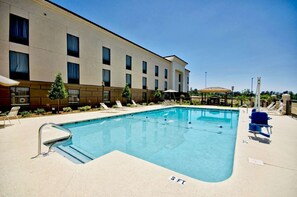 Una piscina al aire libre, sombrillas, tumbonas