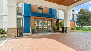 A hotel entrance with a brick pathway leading to a glass door. - Hampton Inn & Suites Tifton (Tifton)
