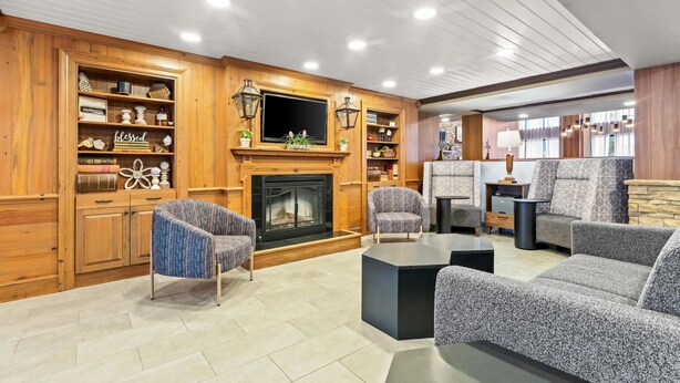 A cozy living room with a fireplace, built-in shelves, and comfortable seating. - Hampton Inn & Suites Tifton (Tifton)