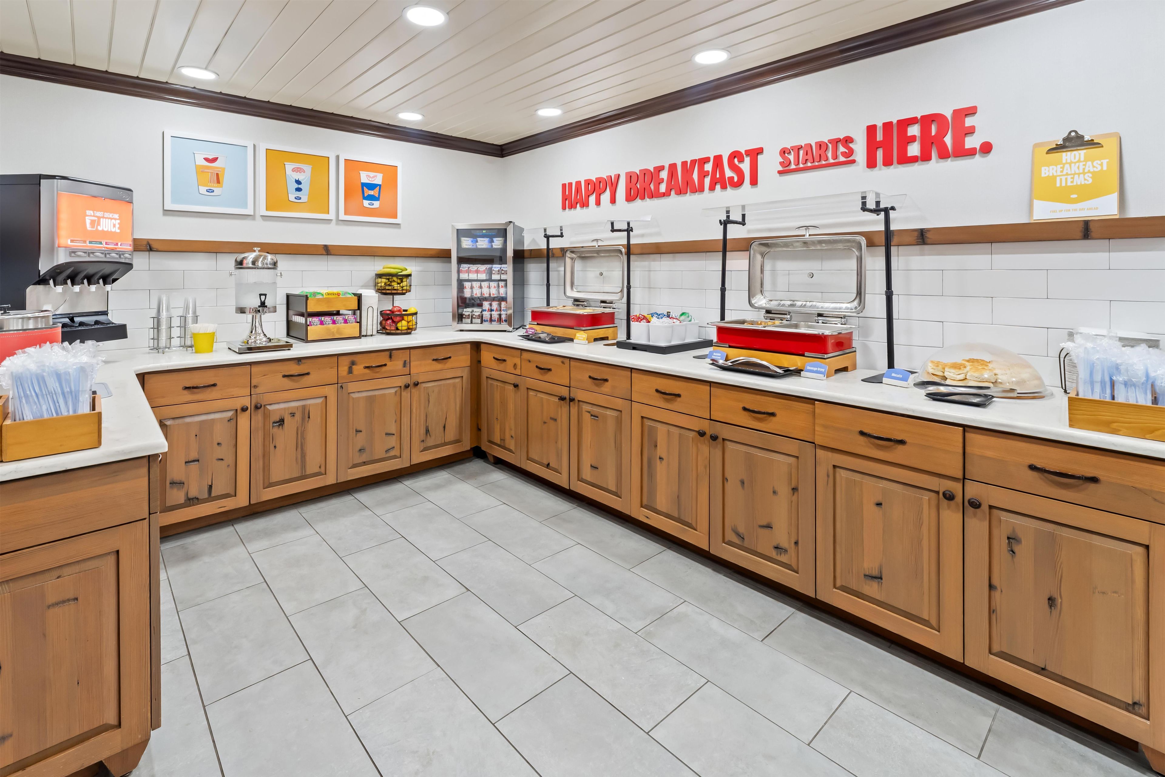 A breakfast area with a counter, coffee machine, and various food items.