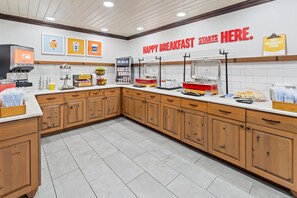 Un comedor con mostrador, cafetera y diversas opciones de comida.