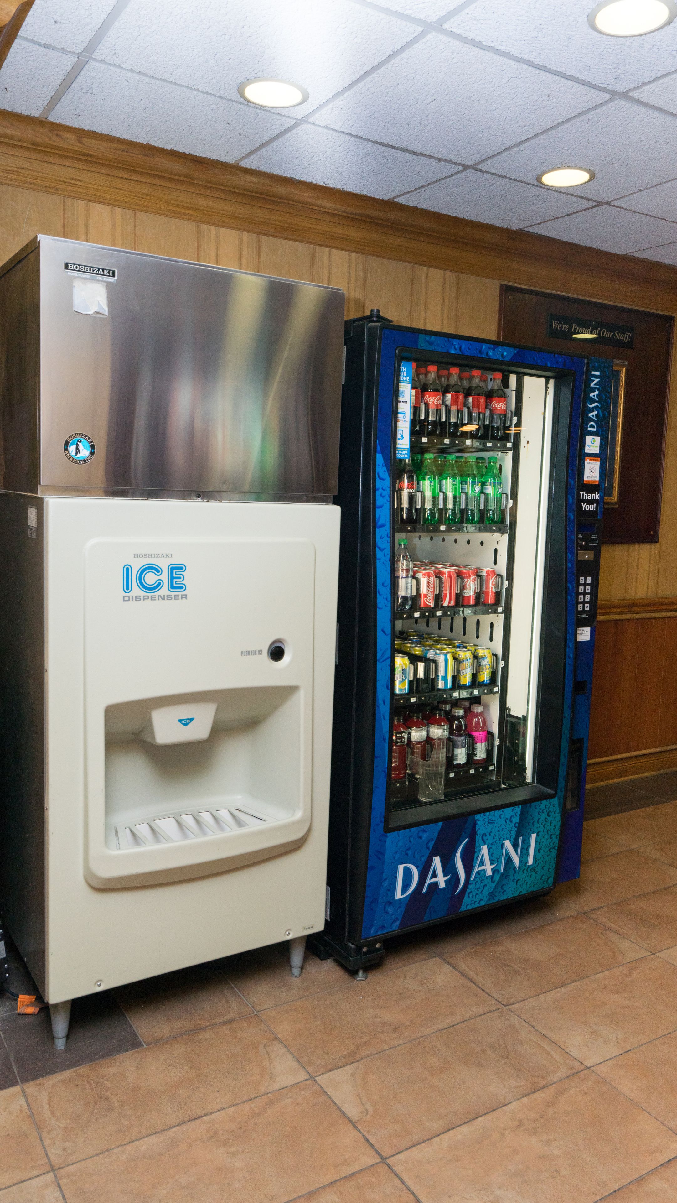 Una máquina expendedora con dispensador de Coca-Cola y enfriador de agua Dasani.