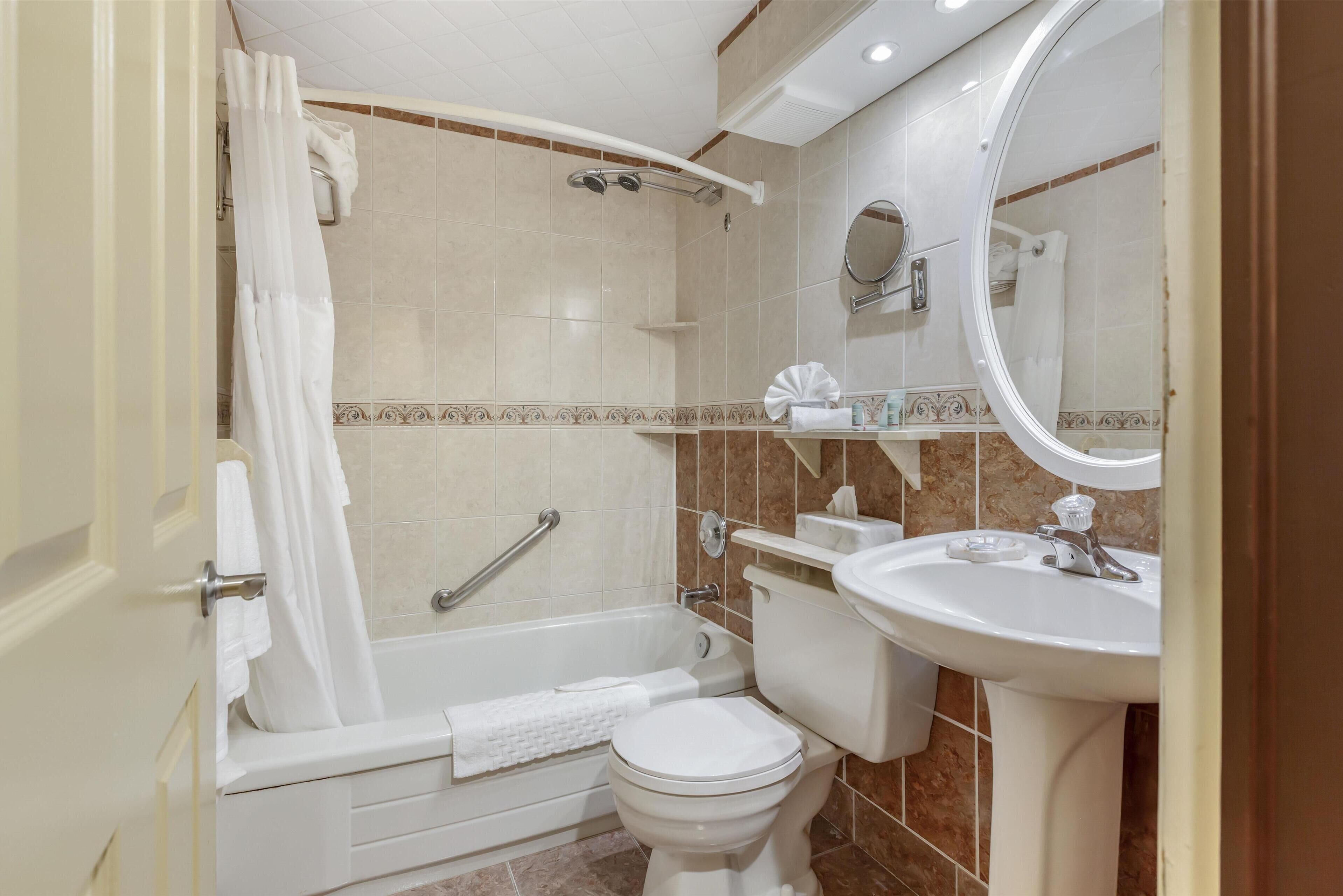 A bathroom with a bathtub, toilet, and sink.