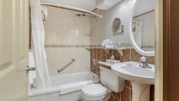 A bathroom with a bathtub, toilet, and sink.