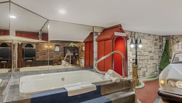 Et moderne badeværelse med et stort badekar, et spejl og en rød telefonboks.