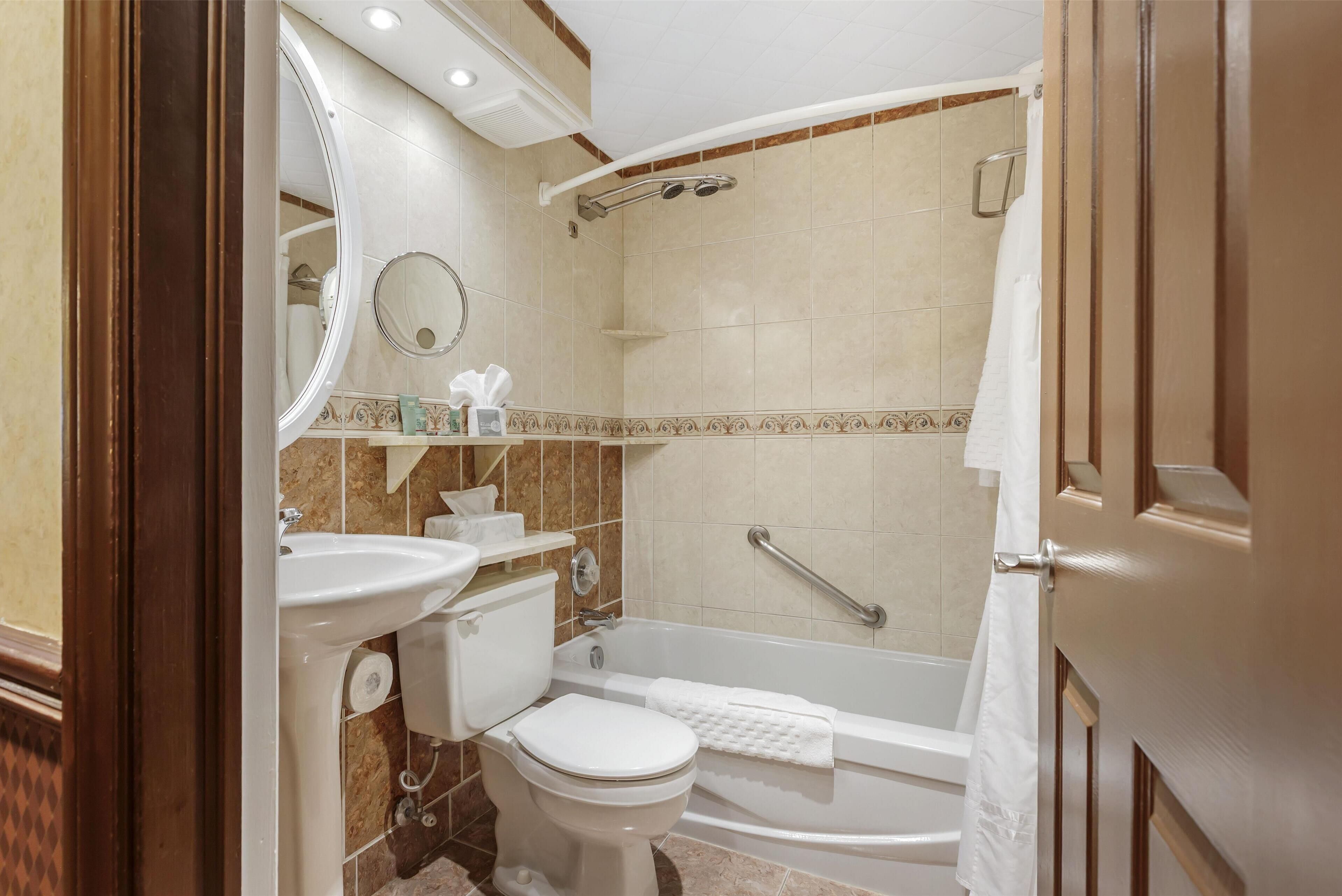 A bathroom with a toilet, sink, and bathtub.