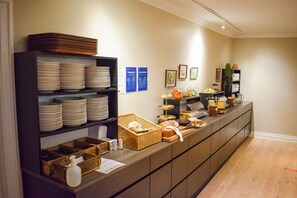 Montaje tipo buffet con platos, cestas y diferentes alimentos.