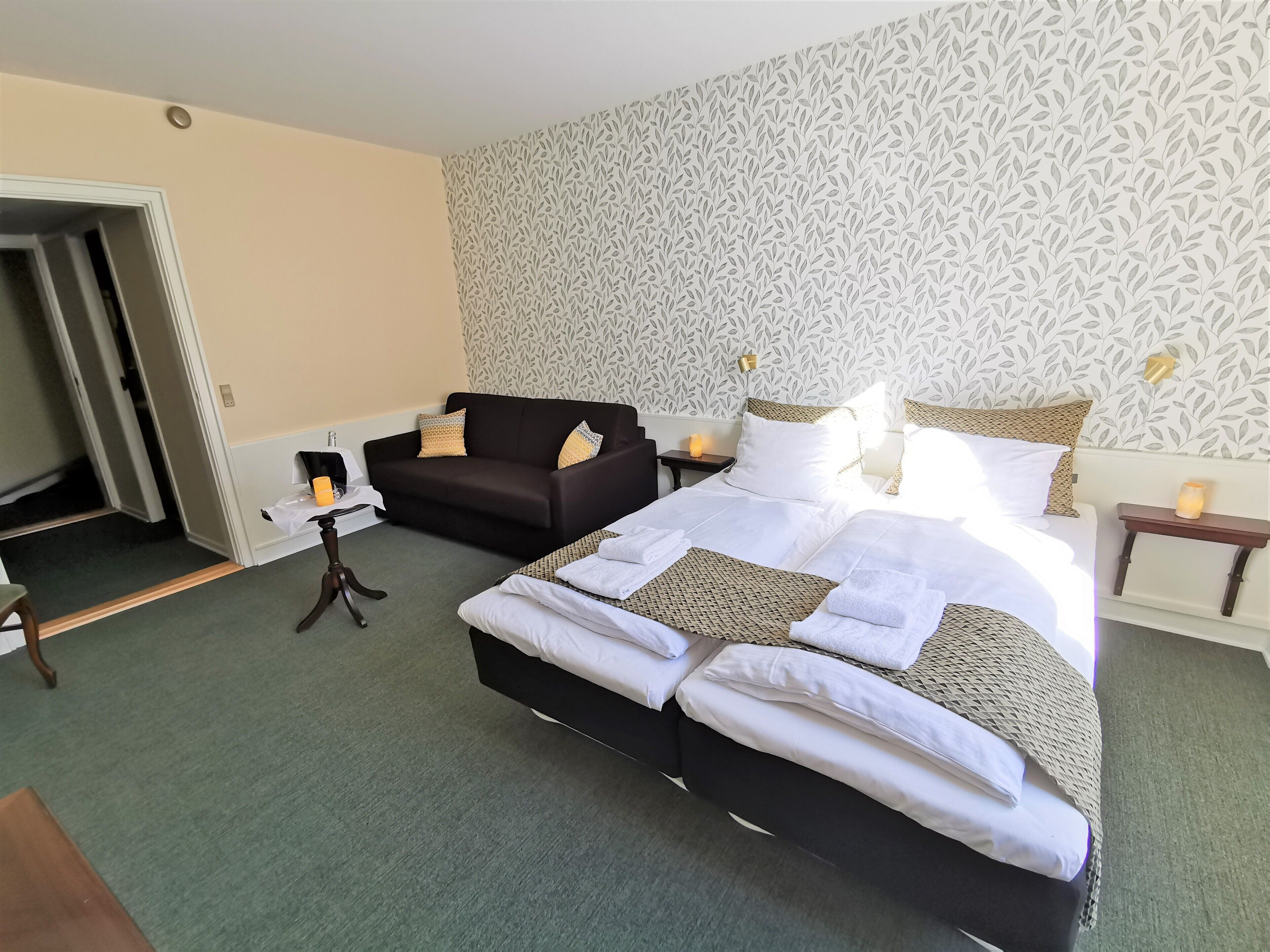 Een hotelkamer met een groot bed, een bank en een kleine tafel.
