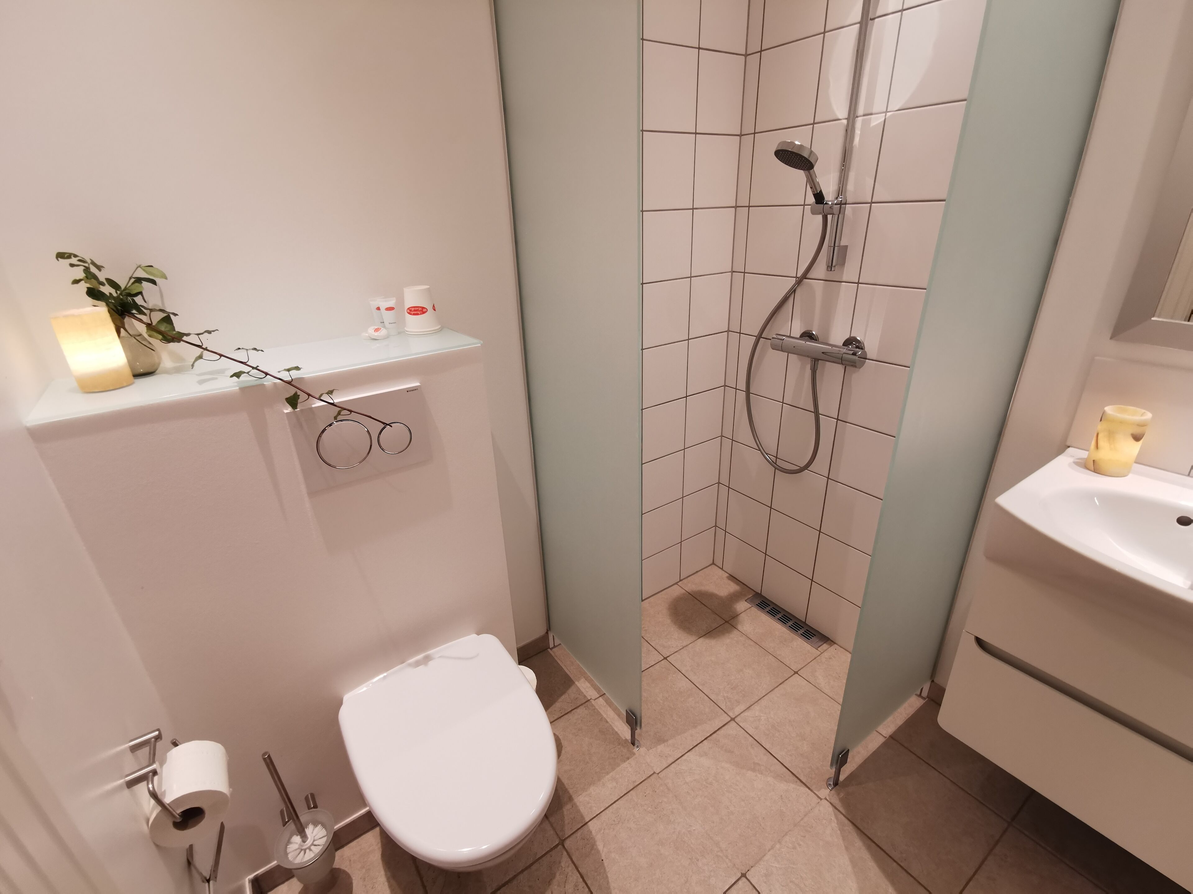 Een badkamer met toilet, wastafel en douche.