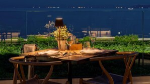 A dining table set for two with a view of the sea. - Coral Hotel Athens (Palaio Faliro)