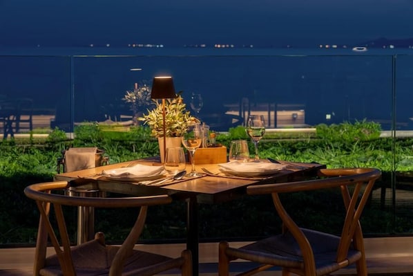 A dining table set for two with a view of the sea. - Coral Hotel Athens (Palaio Faliro)