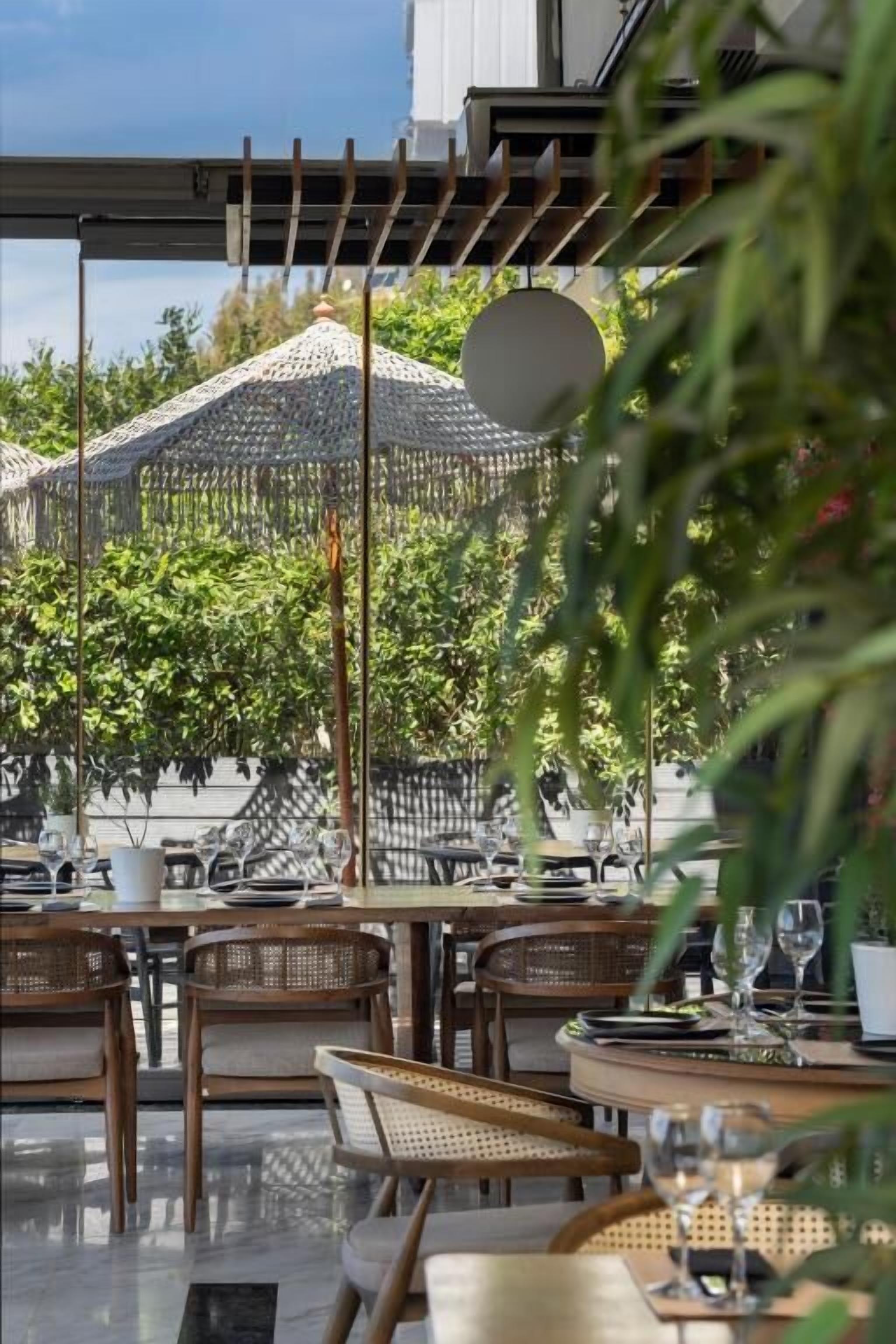 An outdoor dining area with wicker furniture and a pergola.