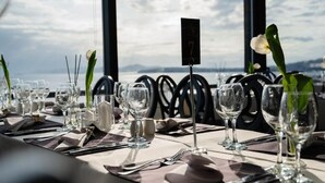 A table set for dining with a view of the sea, numbered 7, and simple tableware. - Coral Hotel Athens (Palaio Faliro)