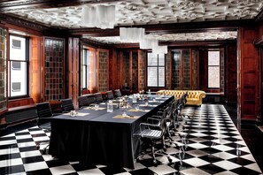 A conference room with a long table, chairs, and a yellow sofa.