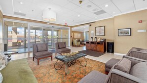 A lobby with seating areas, a reception desk, and a view through glass doors. - Forest Park Hotel by MDR (St. Louis)