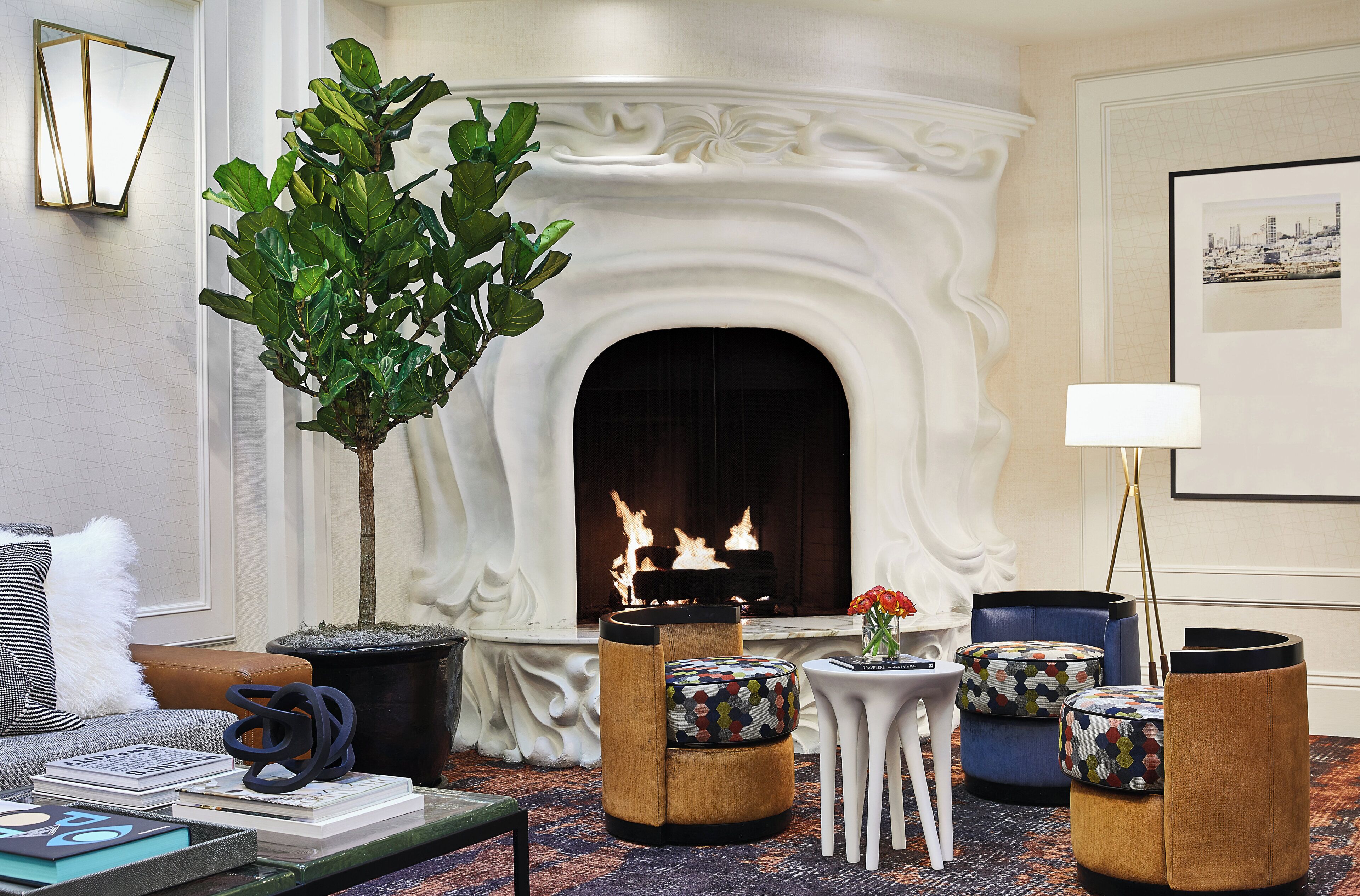 A cozy living room with a fireplace, comfortable seating, and a decorative plant.