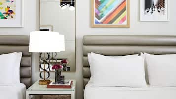 Una habitació d'hotel de disseny modern, amb un llit gran, una taula de nit amb una làmpada i obra d'art a les parets.