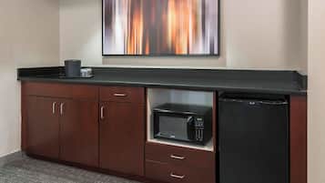 A kitchenette with a microwave, a small refrigerator, and a coffee maker on the counter.