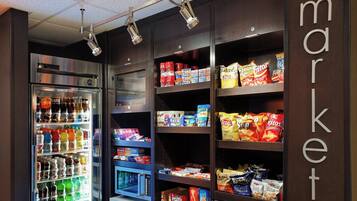 A vending machine stocked with snacks and beverages, and shelves with packaged goods.